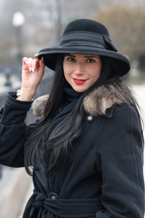 A nice girl in a beautiful gray coat and hat walks in the park on a cold autumn / winter day. Portrait photography.
