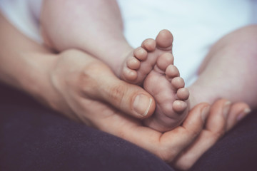 Mother holding baby's tiny feet in her hand