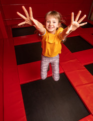 Happy little girl having fun while jumping on trampoline