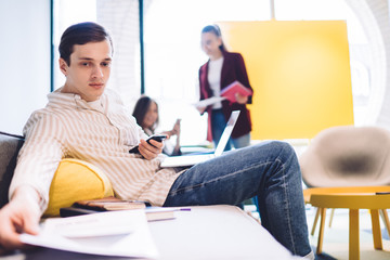 Casual worker with mobile and documents in company