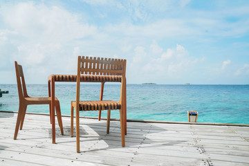 Fototapeta na wymiar Outdoor terrace with Empty wooden table and chair with Sea view of Indain ocean, Maldives background