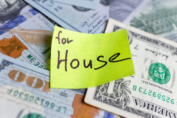 Yellow stick notes on an USD money background. Saving money for house concept