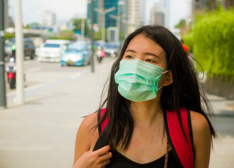 young beautiful and attractive Asian Chinese student woman walking on city street wearing...