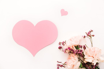 bouquet of flowers on the white background with pink paper heart symbol of love