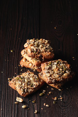 Pile of healthy cookies with sunflower and pumpkin seeds with peanut on wooden board