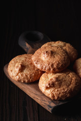 Closeup of almond cookies with golden crust on dark background