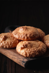 Closeup of almond cookies with golden crust on dark background