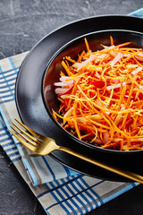 Fresh carrot salad in a black bowl