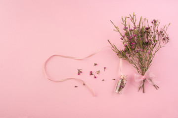 Dried flowers on pink background
