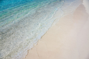 Fototapeta na wymiar Sea shore sand and turquoise blue water wave