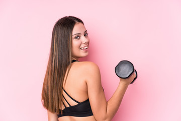 Young caucasian sporty woman holding a dumbbell