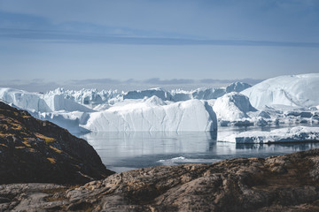 Arctic nature landscape with icebergs in Greenland icefjord with midnight sun sunset sunrise in the...