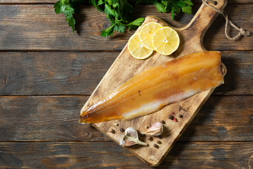 Fish muksun or whitefish cold smoked on a wooden Board. Smoked fish. Top view with space for text