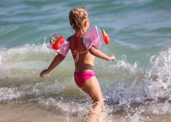 Fototapeta premium A girl runs on the water on the seashore