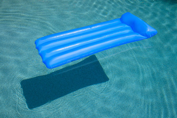 inflatable air matress in a swimming in pool with a shadow