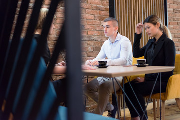 Full concentration at work. Group of young business people working and communicating while sitting at the modern  coffee shop.