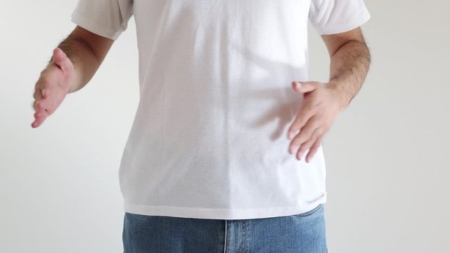 自分のお腹を軽くたたくシャツを着た男性
