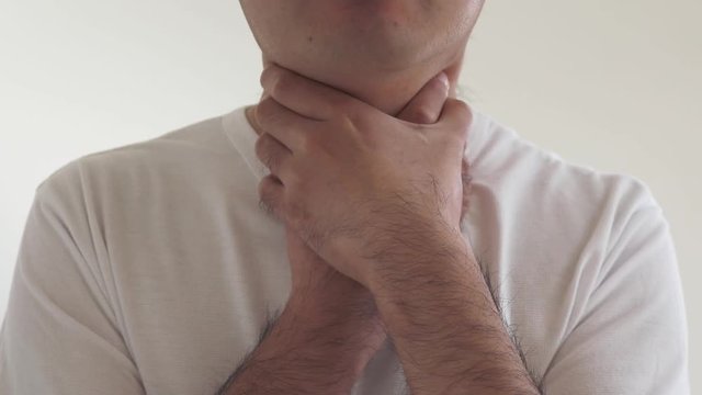 自分の首を自分の手で絞める男性