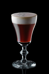 Glass of espresso martini isolated on black background