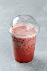 raspberry smoothie in a plastic takeaway glass