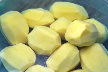 Peeled potatoes in a bowl of water for cooking