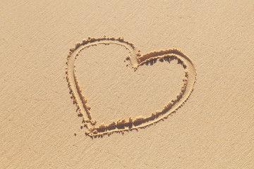 Obraz na płótnie Canvas Hand-drawn heart sign is on a coastal sand