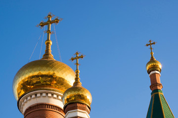 Three domes of the Orthodox Church against the blue sky.