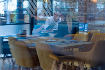 Full concentration at work. Group of young business people working and communicating while sitting at the modern  coffee shop.
