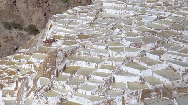 Salinas de Maras - Amazing pattern of salt terraces in the Sacred Valley of the Incas near Cusco, Peru. Salt workers in salt pans.