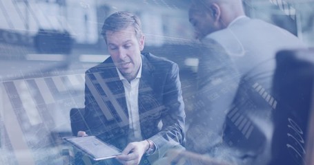 Digital composite of diverse business people in a meeting in office using digital tablet with graphics moving over the screen - Powered by Adobe