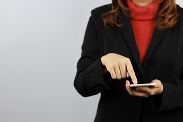 Business woman wearing black and red business suit uniform holding and touching mobile phone with confident on white background studio (advertisement concept)