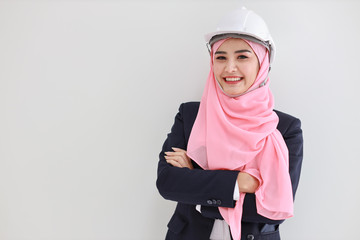 Bueautiful engineer muslim young asian woman wearing blue suit smiling confident in studio. Isolated white background portrait with beautiful face girl with pink hijab. Advertisement portrait concept.