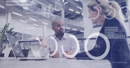 Digital composite of diverse business people in a meeting in office using digital tablet with graphics moving over the screen - Powered by Adobe