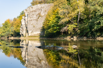 Autumn landscape with Cockerel Rock reflected in mountain river Psekups.  Sunny day in resort area of Goryachiy Klyuch. Krasnodar region. Excellent Nature concept for design. Selective focus.