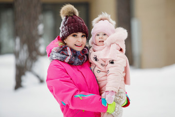 Mom and daughter in a snowy park.