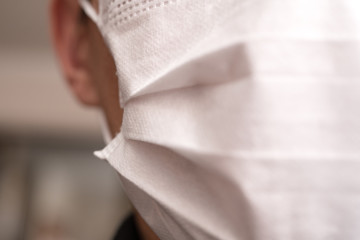 Closeup with the face of a young man wearing medical or surgical mask