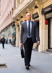 Full-length portrait of businessman walking on street