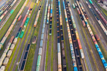 Obraz premium Aerial perspective view of railroad tracks, cargo sorting station. Many different railway cars with cargo and raw materials.