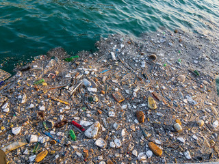  Household garbage in the beautiful turquoise water of the sea, when disposing of garbage you transfer it from one pocket to another.