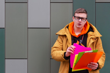 student guy holds books and asks straining your brain