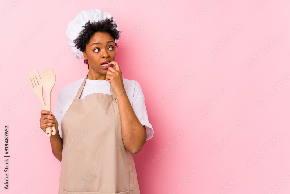 Wall mural young african american cook woman relaxed thinking about something looking at a copy space.