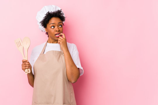Young african american cook woman relaxed thinking about something looking at a copy space.