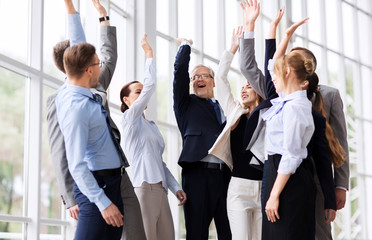 corporate and teamwork concept - happy business team making high five or celebrating success at...