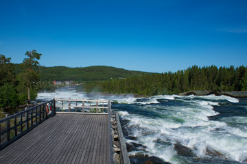 Storforsen river Sweden. Nature reserve on sunny summer day in Swedish lapland with Big river, rapids and waterfall.