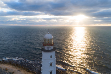Seascape at sunset. Lighthouse on the coast. Aerial view.