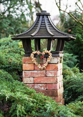 Homemade heart shaped bird food hanging on wooden bird feeder house in the garden. Animal wildlife...