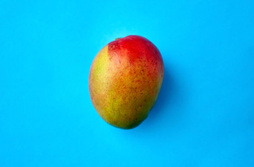 fruits, diet and food concept - close up of ripe mango on blue background