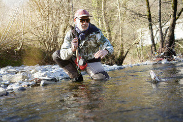 catch of a rainbow trout by a fly fisherman in the river