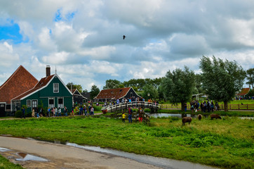 Zaanse Schans, Holland, August 2019. Northeast Amsterdam is a small community located on the Zaan River. View of the pretty wooden houses of the village, mainly green in color. Cloudy day.