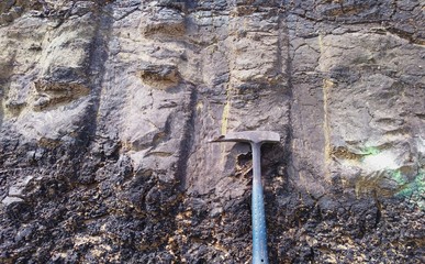 rocks Outcrop with geology hammer
